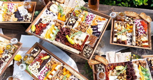 Creative charcuterie boards arranged with gourmet meats, cheeses, fruits, and nuts in rustic wooden trays.