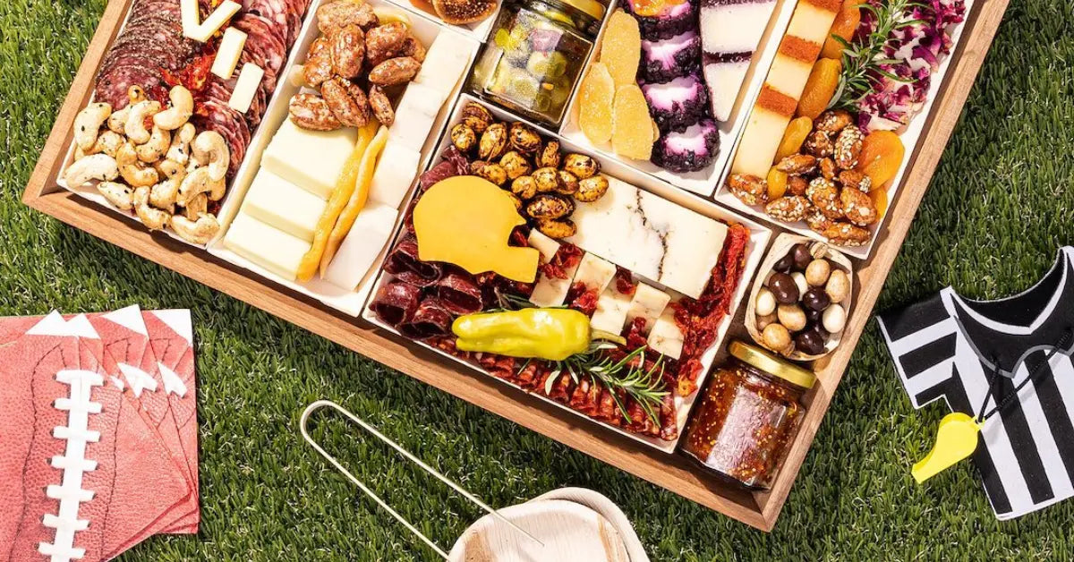Game day snack platter with an assortment of cheeses, meats, and nuts, styled with football-themed napkins and referee accessories