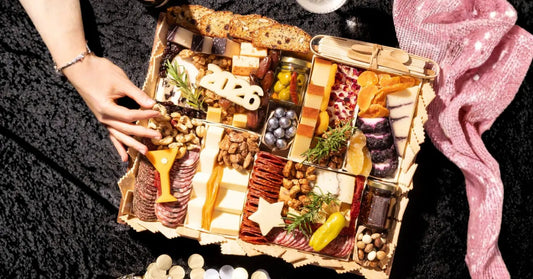 Best cheese for charcuterie arranged on an overhead board with assorted meats, nuts, fruits, and crackers