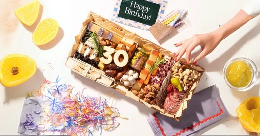 Birthday charcuterie board filled with meats, cheeses, nuts, and treats, featuring a festive "30" centerpiece and party decor.