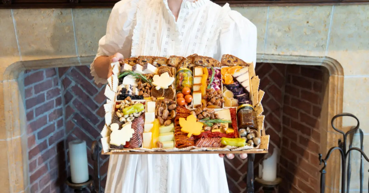 Fall charcuterie board with autumn leaf-shaped cheeses, meats, nuts, dried fruits, and crackers arranged in a festive tray