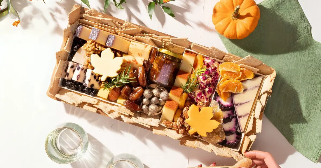 Fancy cheese board featuring artisanal cheeses, dried fruits, nuts, fig jam, and crackers, elegantly arranged with autumn-themed decorations