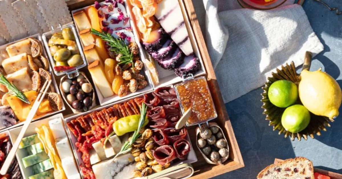 Monogrammed cheese board featuring gourmet meats, cheeses, fig jam, and nuts arranged beautifully with fresh herbs.