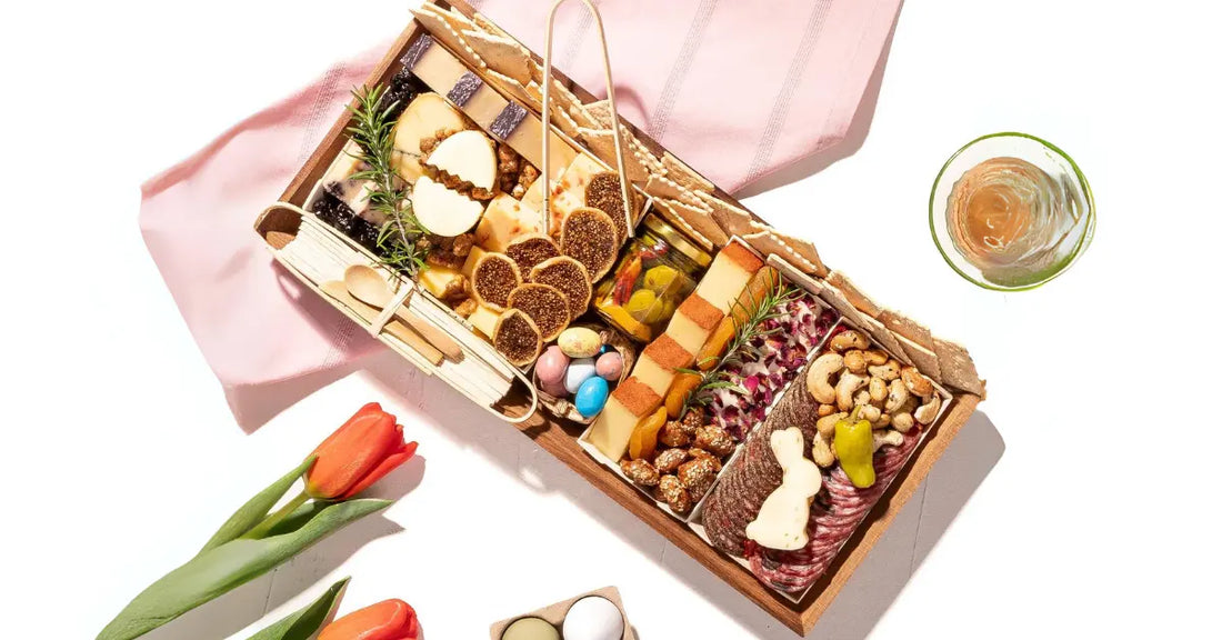 Seasonal charcuterie board with gourmet cheeses, cured meats, crackers, nuts, figs, pickled vegetables, and festive Easter decorations.