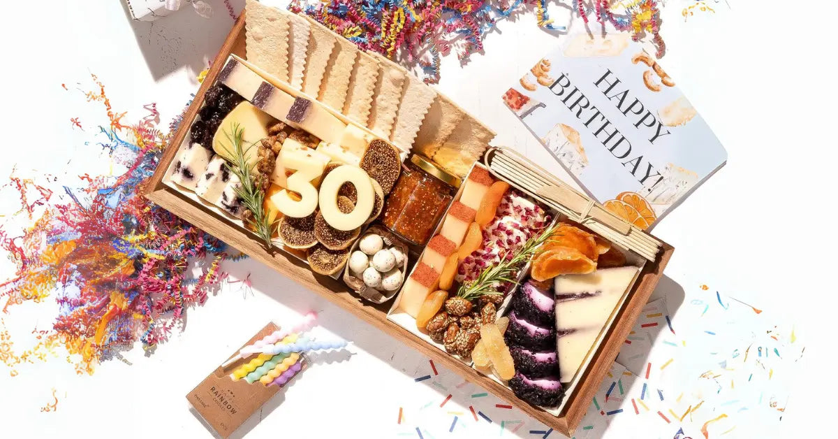 Unique cheese platter designed for a birthday celebration, featuring gourmet cheeses, dried fruits, nuts, crackers, and a festive "30" cheese cutout
