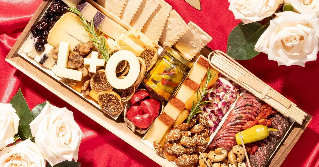 Valentine's Day charcuterie board featuring cheeses, meats, figs, crackers, and roses, arranged on a red satin backdrop