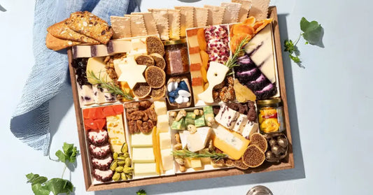 vegetarian charcuterie board featuring assorted plant-based cheeses, crackers, candied nuts, dried apricots, olives, and rosemary garnish