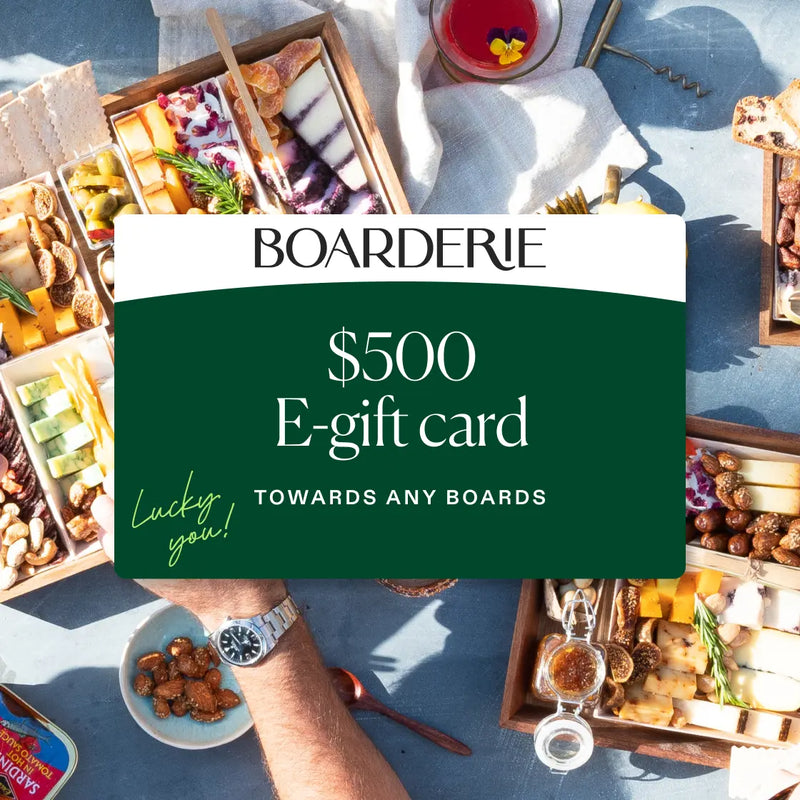Assorted charcuterie boards with cheeses, meats, and nuts, promoting a $500 gift card for any board selection.