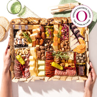 Large charcuterie board gift featuring cured meats, assorted cheeses, nuts, olives, crackers, and fresh garnishes shipped nationwide.