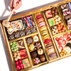 Gourmet dessert gift board featuring over 47 artisan chocolates, brownies, macarons, cakes, truffles, caramels & more on a reusable acacia wood board. Smash the chocolate box for a surprise.
