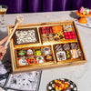 Small Halloween dessert board with assorted chocolate truffles, brownie bites, and candy in a gold-lined wooden tray, featuring a "Happy Halloween" chocolate plaque and a personalized wooden mallet.