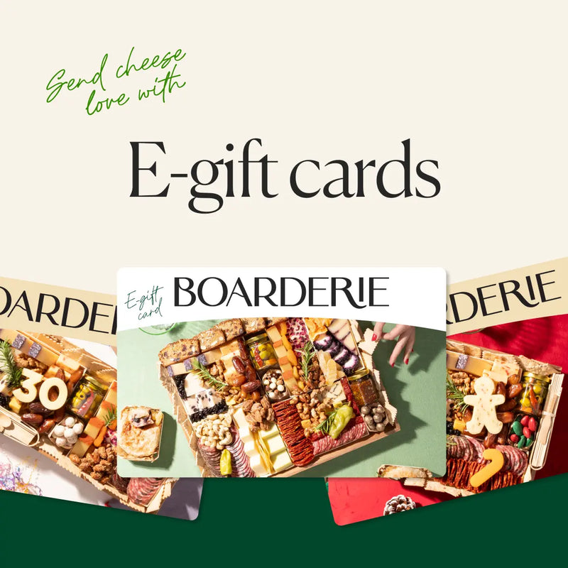 Charcuterie board with meats, cheeses, nuts, and fruits, promoting gift cards for cheese lovers.