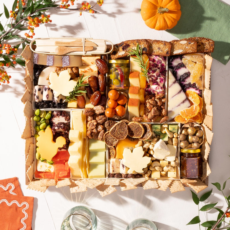 Thanksgiving charcuterie board featuring a variety of cheeses, dried fruits, nuts, figs, and turkey & leaf-shaped cheese pieces