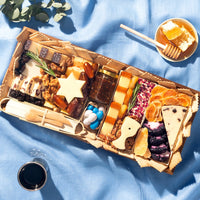 Charcuterie board delivered for the Jewish holiday with cheeses, dried, fruits and nuts themed for Hanukkah. The perfect gift.