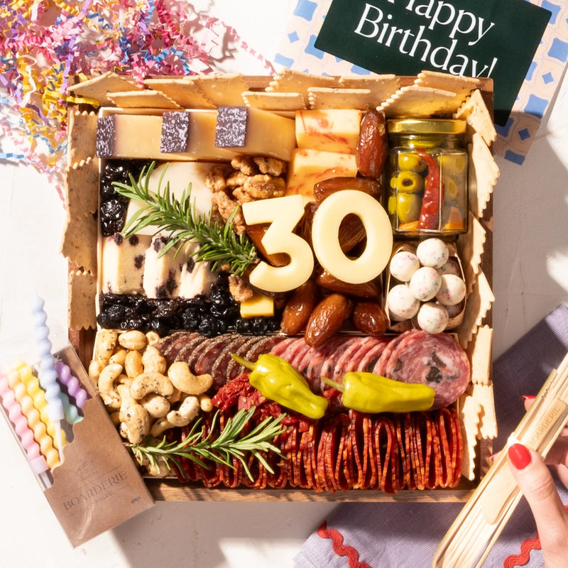 birthday charcuterie board with "30" in cheese, featuring meats, nuts, cheeses, & a festive "happy birthday" card