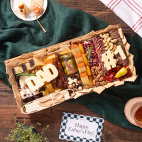 Father's Day cheese board featuring gourmet cheeses, meats, nuts, pickled vegetables, chocolate-covered snacks, and “DAD” and “#1” cheese cutouts, beautifully arranged in a gift box with crackers and a “Happy Father's Day” card.