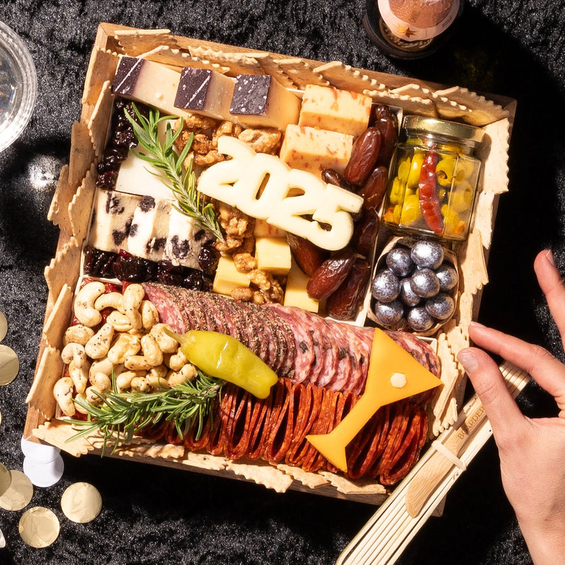 Charcuterie board New Years themed with year and martini cut outs. This is a small board featuring over 17 ingredients.