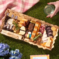 Easter themed cheese board with gourmet cheeses, fig jam, nuts, dried fruits, candy eggs, and festive bunny and egg-shaped cheese.