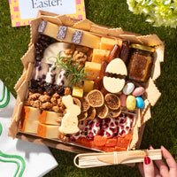 Charcuterie for Easter featuring cheeses, dried fruits, nuts, fig jam, candy eggs, and festive bunny and egg-shaped cheese cutouts.