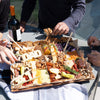 Father’s Day charcuterie board with “DAD” cheese letters, cheeses, meats, nuts, and crackers, shared outdoors with family.