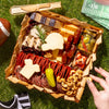 Gourmet food platter with NFL-themed items on a grassy surface