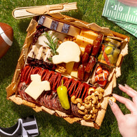 Gourmet food platter with NFL-themed items on a grassy surface