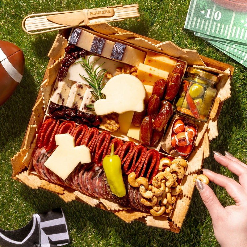 Gourmet food platter with NFL-themed items on a grassy surface