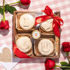 Valentine's Day-themed baked brie board with pastries spelling "I love you," decorated with a red bow and roses.