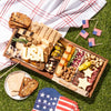 large labor day themed charcuterie board with assorted cheeses, meats, nuts, & crackers, featuring cheese cutouts shaped like "USA" & stars