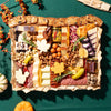 large thanksgiving charcuterie board with assorted cheeses, meats, nuts, & fall-themed accents on a green tablecloth