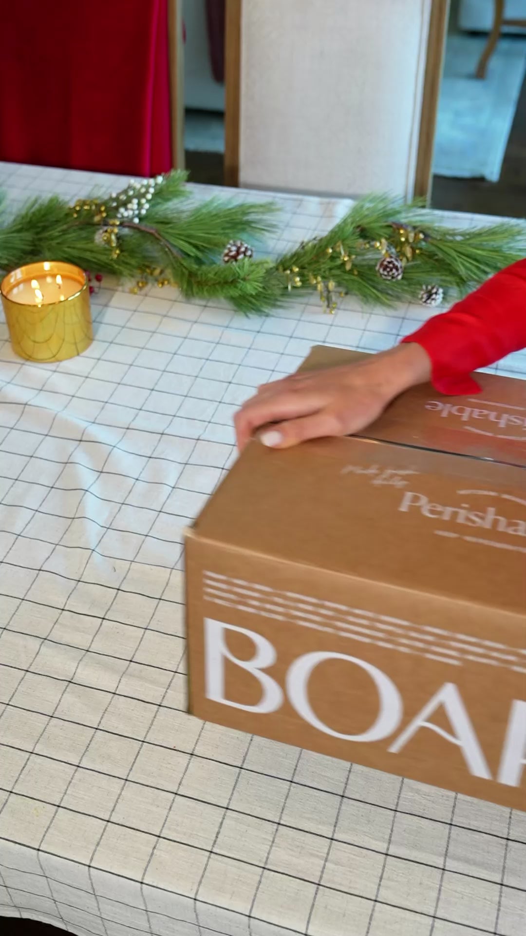 Unboxing a Boarderie holiday charcuterie board with Christmas music playing and festive decorations.