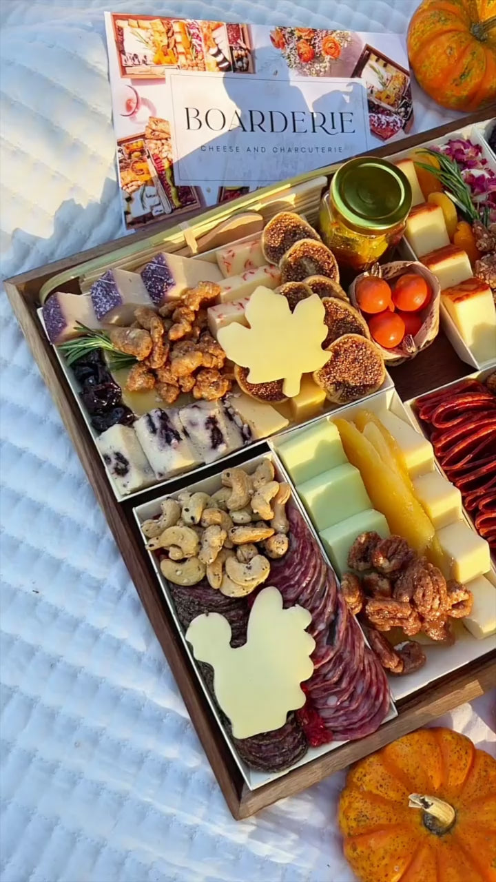 Thanksgiving cheese and meat board with turkey cut out fall decorations around the board.