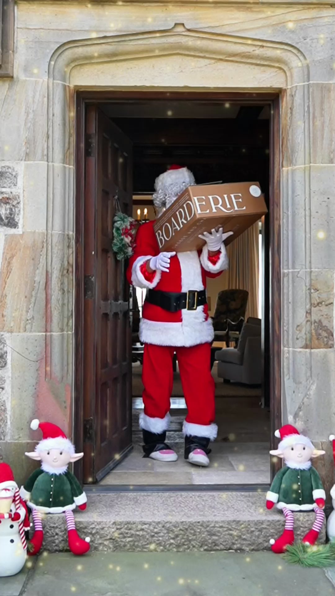 Santa Claus receiving and unboxing a Boarderie charcuterie board.