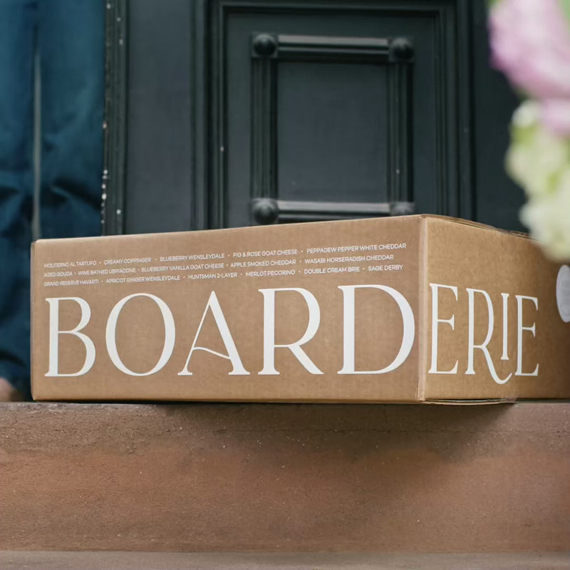 Charcuterie board delivered to font door and being unboxed. An open charcuterie board gift on the table being enjoyed, a couple smiling and clinking glasses together and a spread of people enjoying a grazing table