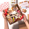 small Valentine's Day charcuterie gift box with "XO" & heart-shaped cheeses, nuts, figs, cured meats, and a red "Love You" ribbon