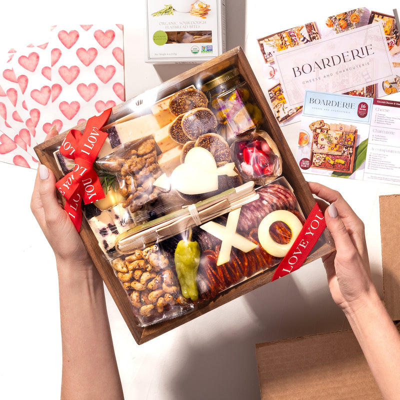 small Valentine's Day charcuterie gift box with "XO" & heart-shaped cheeses, nuts, figs, cured meats, and a red "Love You" ribbon