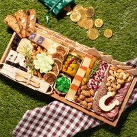 St. Patrick’s Day cheese board featuring artisanal cheeses, nuts, figs, pickled vegetables, and festive shamrock and horseshoe cheese cutouts.