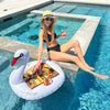 woman enjoying summer by the pool with a charcuterie board on a swan floatie, holding a glass of rosé