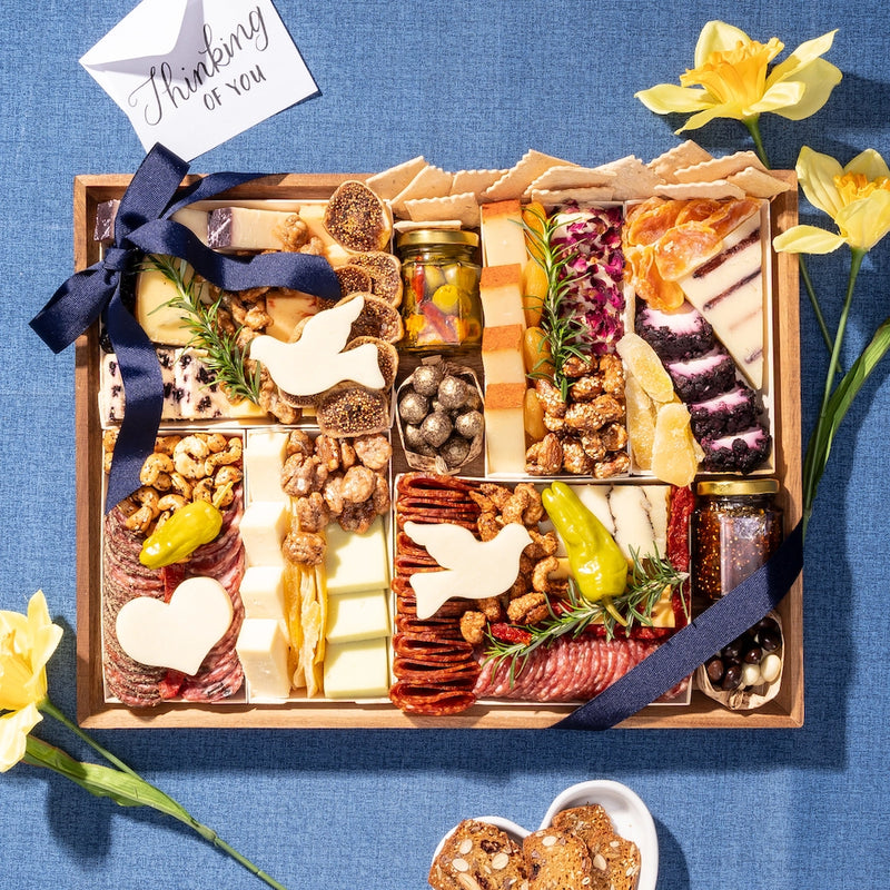 large Sympathy charcuterie board with a dove-shaped cheese, nuts, & meats, arranged with a letter saying "Thinking of you"